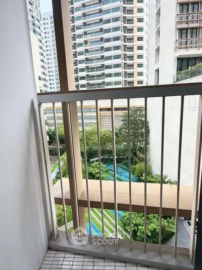 Charming balcony view overlooking lush garden in modern high-rise building.