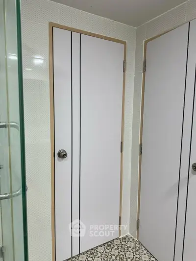 Modern bathroom with sleek white doors and patterned tile flooring