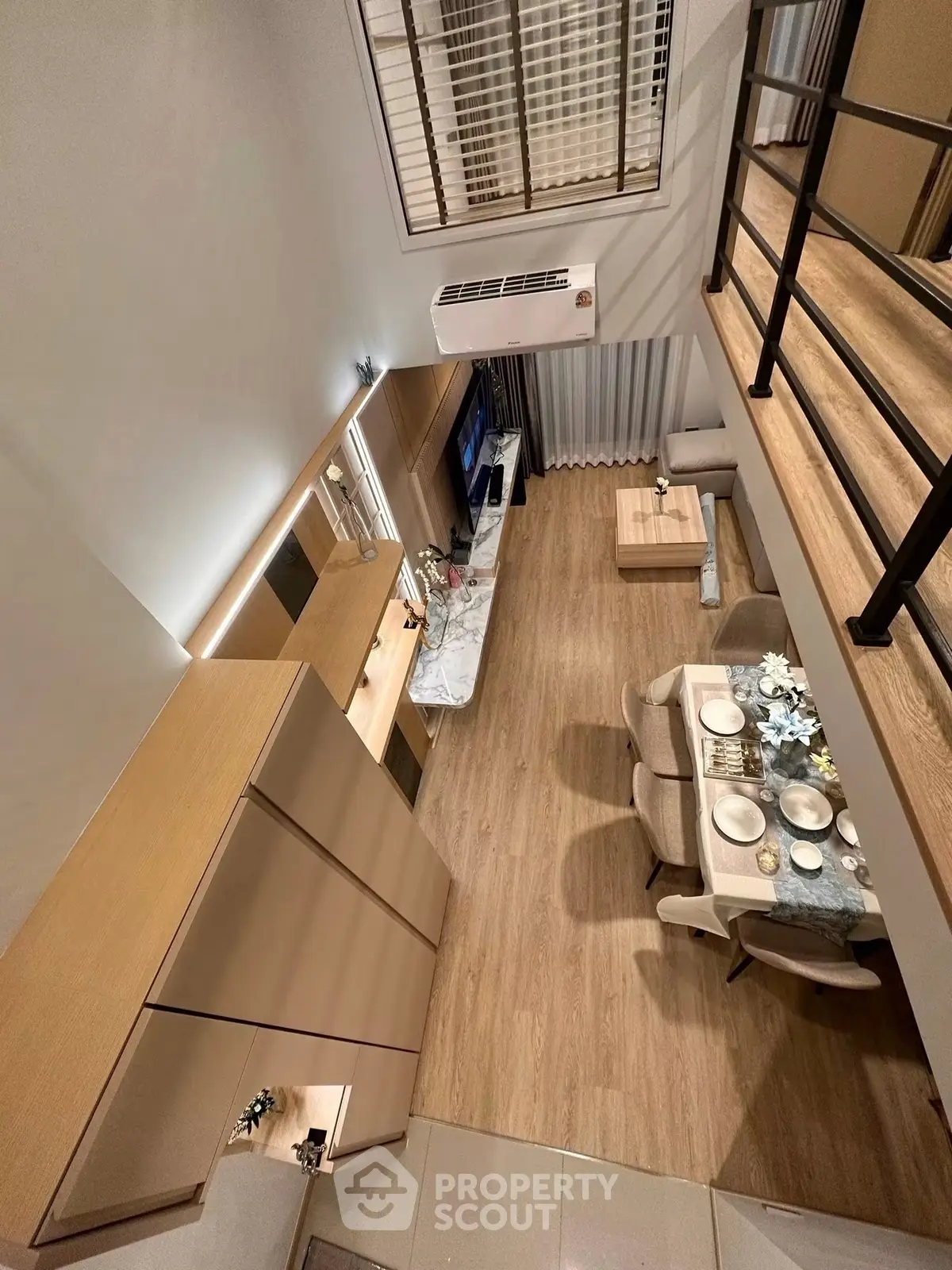 Modern loft-style living room with dining area, high ceiling, and elegant decor.