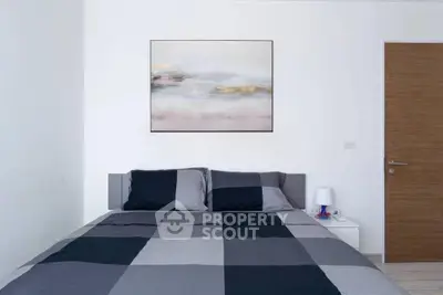 Modern bedroom with stylish decor and cozy bedding in a minimalist design.