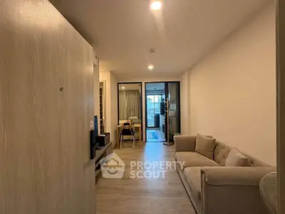 Modern apartment interior with cozy living room and open layout, featuring a stylish sofa and dining area.