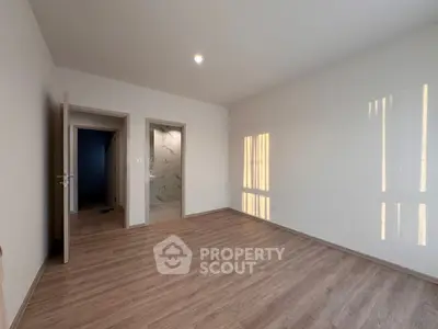 Spacious empty room with wooden flooring and natural light