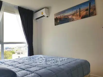 Cozy bedroom with large window and scenic wall art, featuring a comfortable bed and air conditioning.