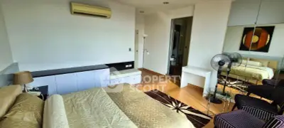 Spacious bedroom with modern decor and ensuite bathroom in luxury apartment.