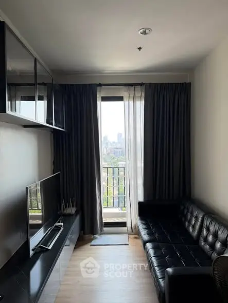 Modern living room with sleek black sofa and city view balcony