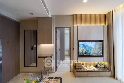 Modern living room with stylish decor and wall-mounted TV in a luxurious apartment.