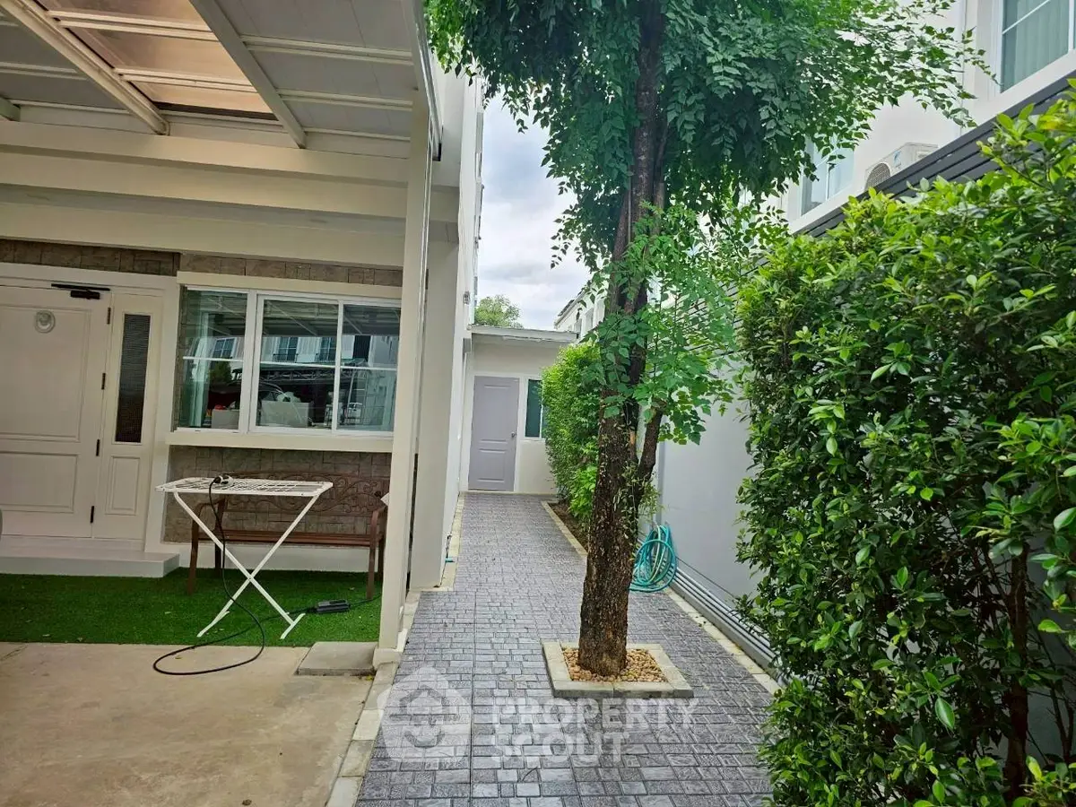 Charming exterior walkway with lush greenery and modern design, perfect for serene outdoor living.