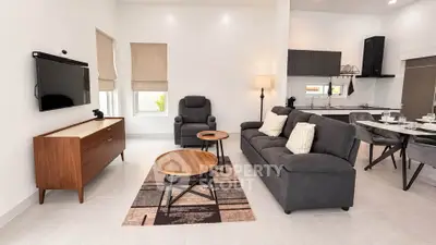 Modern open-plan living room with sleek furniture and integrated kitchen area.
