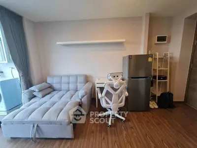 Modern living room with stylish furniture and appliances in a cozy apartment setting.