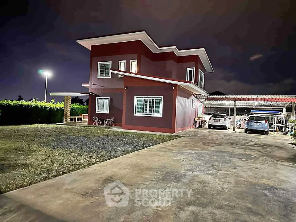 Modern two-story house with spacious driveway and night lighting