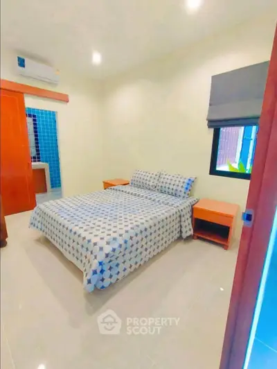 Cozy bedroom with modern decor and ample natural light, perfect for relaxation.