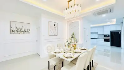 Luxurious dining room with elegant chandelier and modern kitchen in open layout