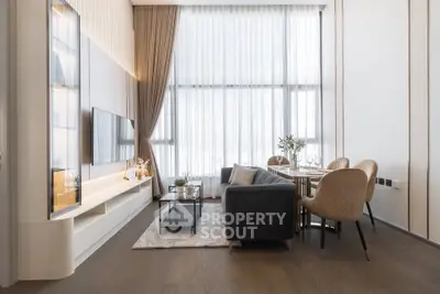 Luxurious modern living room with high ceilings and elegant decor, featuring a cozy seating area and dining space.