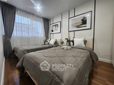 Elegant twin bedroom with modern decor and natural light