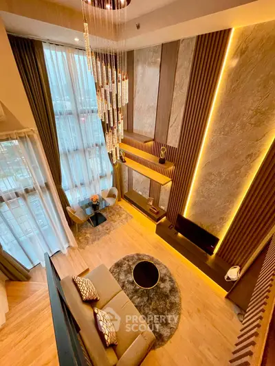 Luxurious high-ceiling living room with modern decor and stunning chandelier