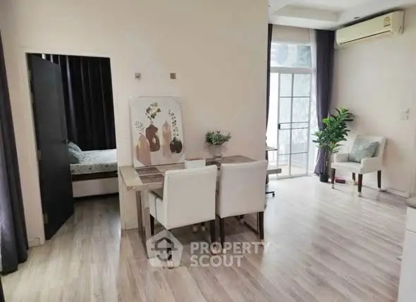 Modern living room with elegant dining area and balcony access, featuring stylish decor and natural light.