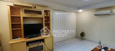 Cozy living room with entertainment center and air conditioning, perfect for relaxation.