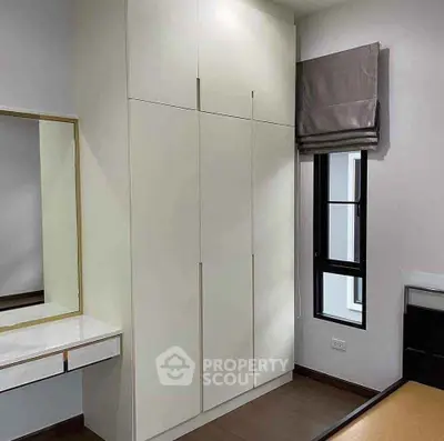 Modern bedroom with sleek wardrobe and stylish vanity in contemporary apartment