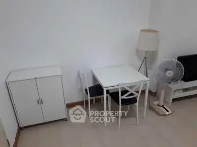 Cozy dining area with white furniture and modern decor in a compact living space.