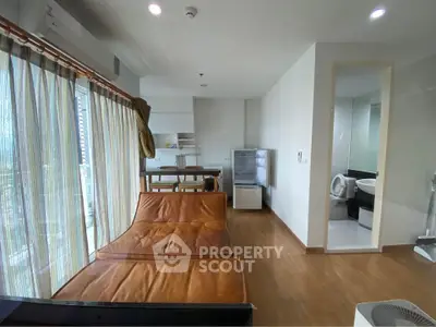 Modern studio apartment with open layout, featuring a cozy living area and a compact kitchen.