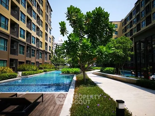 Luxurious apartment complex with stunning pool and lush greenery, perfect for modern living.