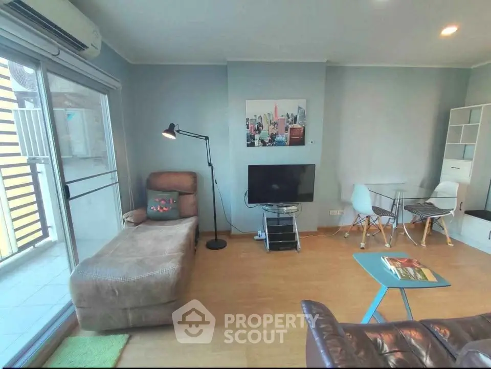 Modern living room with stylish furniture and balcony access in a cozy apartment.