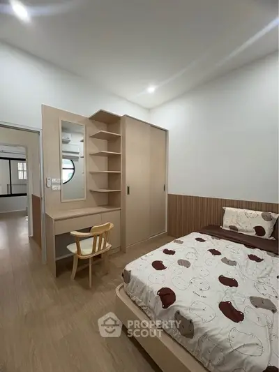 Cozy bedroom with modern wooden furniture and ample storage space, perfect for a comfortable living experience.