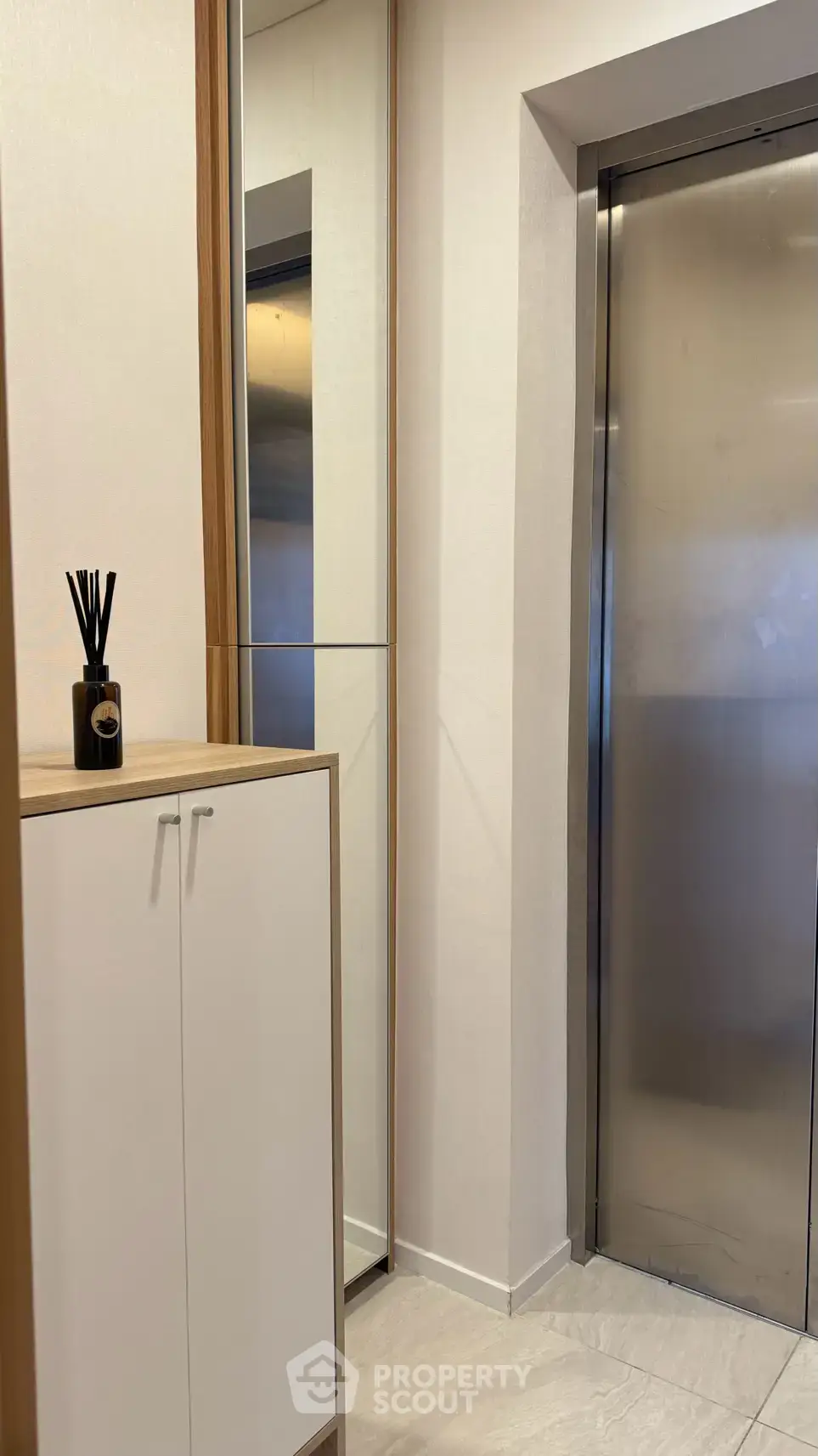 Modern apartment entrance with sleek elevator and stylish decor