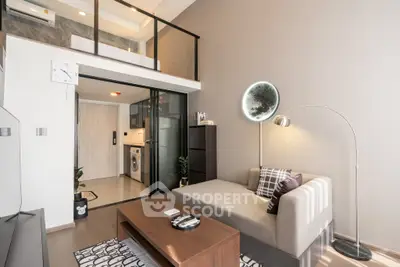 Modern living room with loft, stylish decor, and open kitchen in a chic apartment.