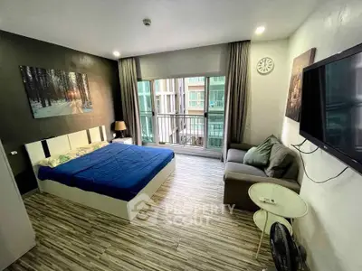 Modern studio apartment with cozy bedroom and living area, featuring a large window and stylish decor.