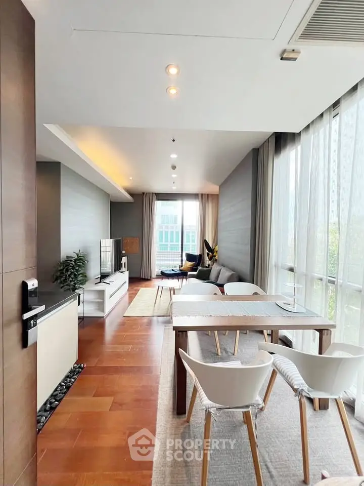Spacious modern living room with elegant decor and large windows offering natural light.