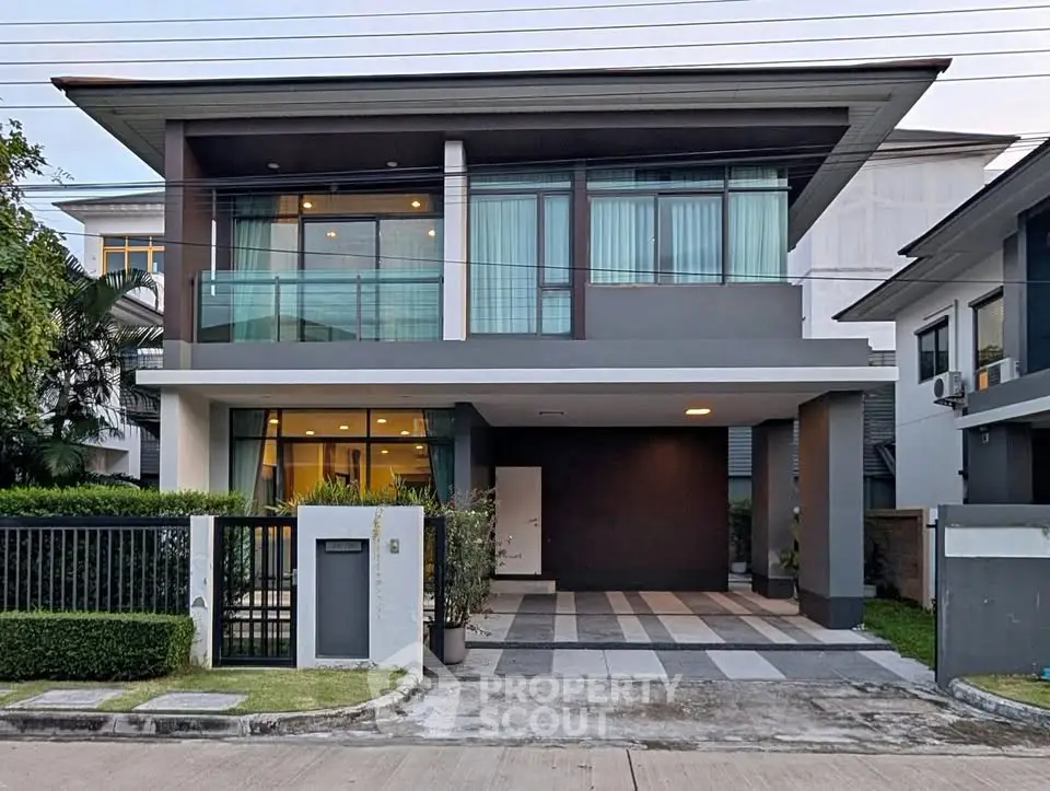 Modern two-story house with sleek design and spacious driveway in a suburban neighborhood.
