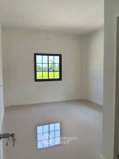 Bright empty room with glossy floor and large window offering scenic views, perfect for customization.