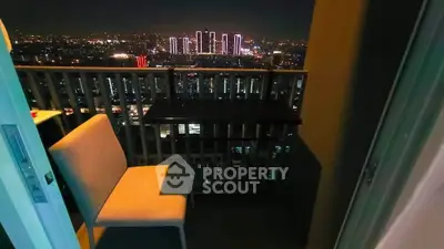 Stunning cityscape view from a cozy balcony at night, perfect for relaxation.