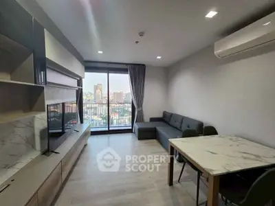 Modern living room with city view, featuring sleek furniture and large windows for natural light.