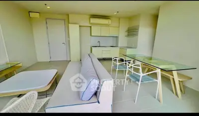 Modern open-plan living room with sleek kitchen and stylish furniture in a bright apartment.