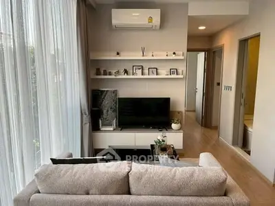 Modern living room with cozy sofa, TV, and stylish decor in a bright apartment.