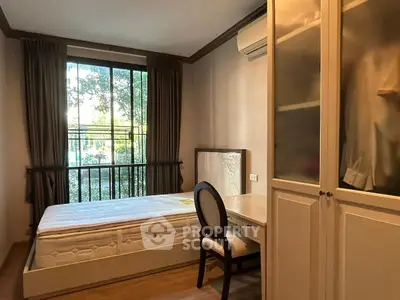 Cozy bedroom with large window and built-in wardrobe, perfect for natural light lovers.