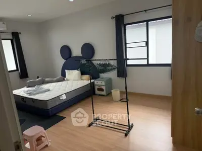 Charming bedroom with unique headboard and ample natural light, perfect for a cozy retreat.
