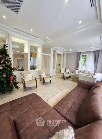 Spacious living room with elegant decor and large brown sofa, perfect for family gatherings.