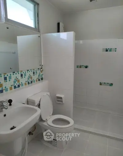 Modern bathroom with tiled shower and mosaic accents