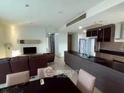 Spacious open-plan living room with modern kitchen and sleek furnishings in a contemporary apartment.