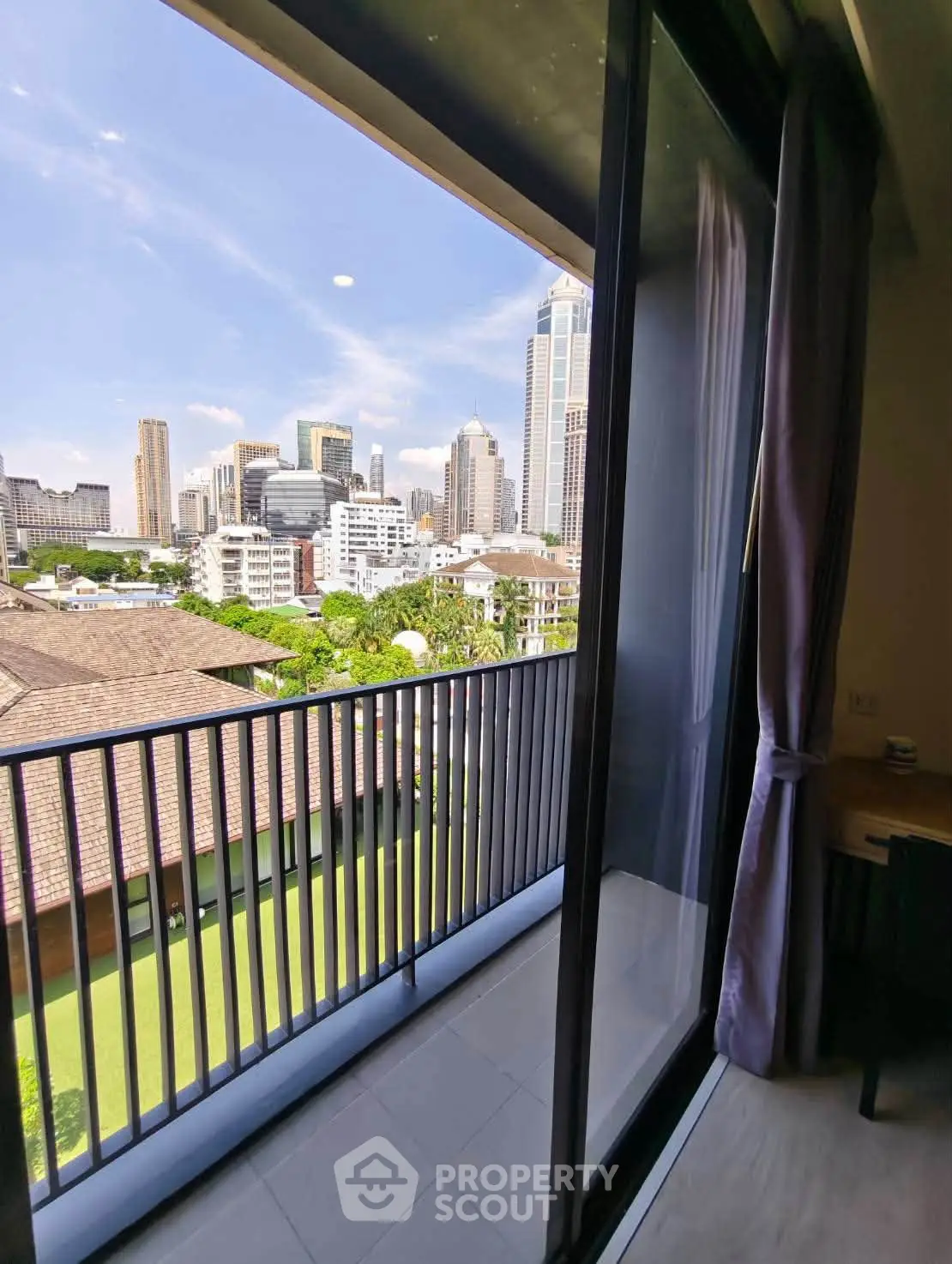 Stunning city view from modern apartment balcony with sliding glass doors.