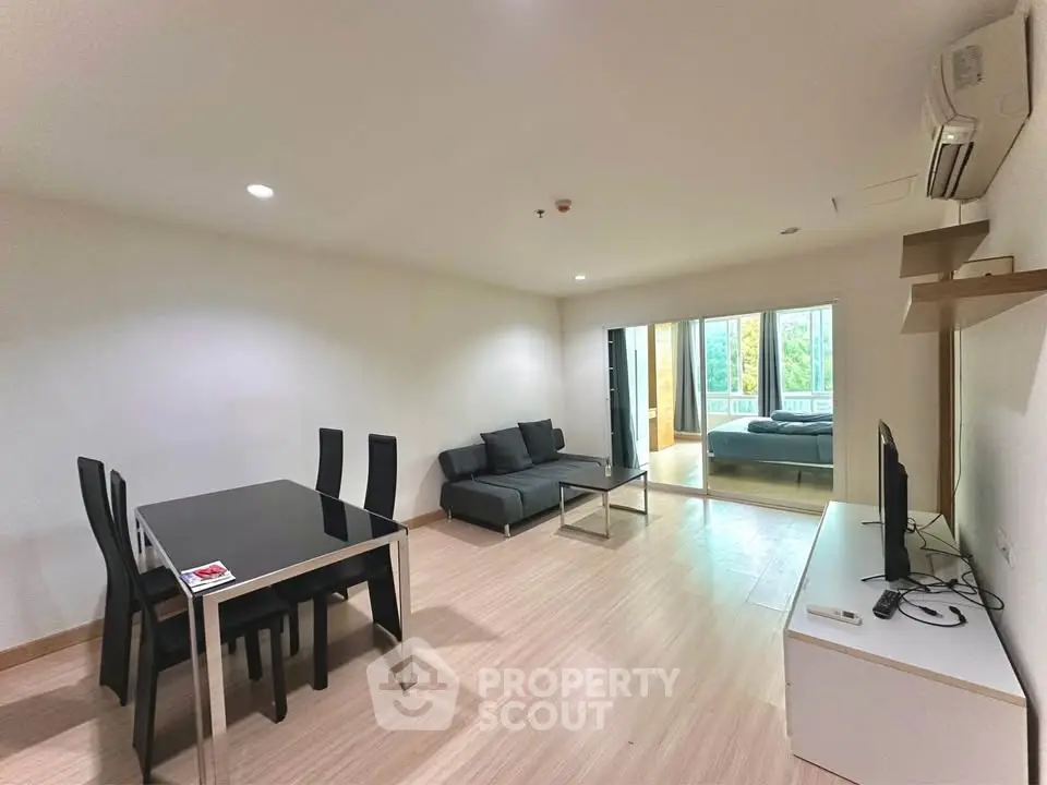 Spacious modern living room with dining area and large windows offering natural light.
