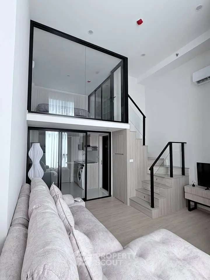 Modern loft apartment with mezzanine, stylish living area, and sleek kitchen design.