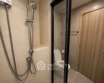 Modern bathroom with glass shower and sleek fixtures in contemporary apartment.