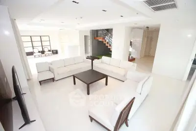 Spacious modern living room with white sofas and sleek design