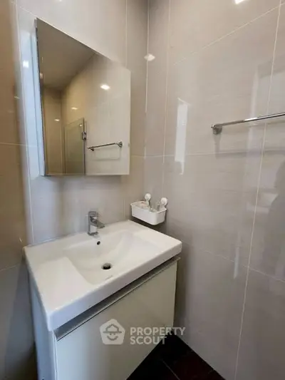Modern bathroom with sleek sink and mirror in a compact space.