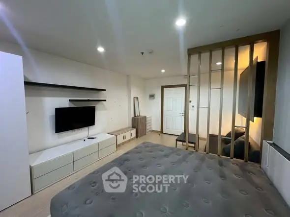 Modern studio apartment with stylish partition and wall-mounted TV