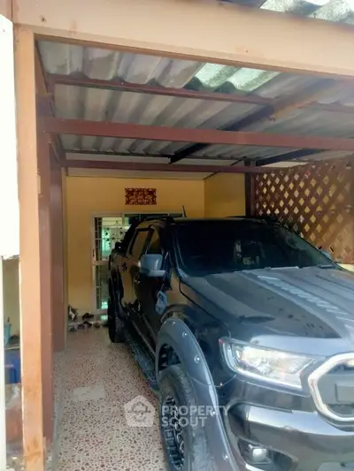 Covered parking space with a black SUV in a residential property.